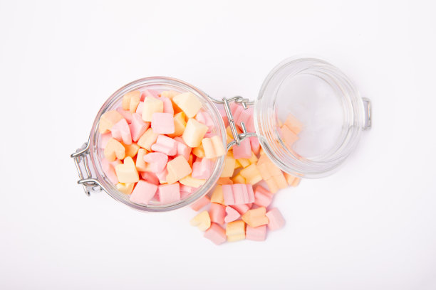 棉花糖装在玻璃罐里，孤立在白色背景上。水果味的糖果。草莓棉花糖图片下载