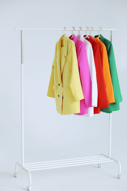 多色明亮的夹克挂在白色背景的衣架上。图片下载