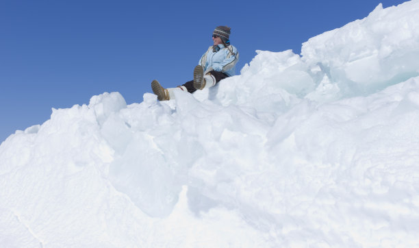 坐在北极冰脊上的女人。图片下载