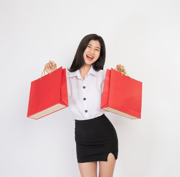 一个拿着红色购物袋的年轻亚洲女士的瞬间和表情图片下载