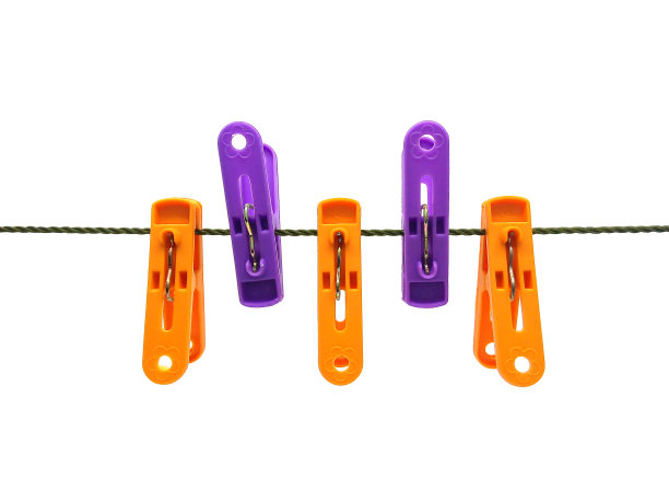 白色背景上孤立的绿色衣绳上的塑料衣别针。图片下载