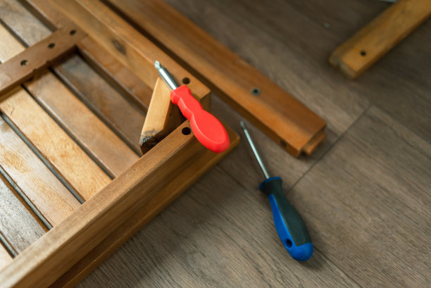 家具装配工用螺丝刀组装家具。有工具的师傅修理家具。爸爸在家里收集家具图片下载