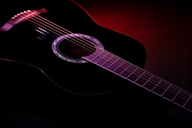 黑色吉他在黑暗的背景下，红色的光束。吉他音乐低调概念图片下载
