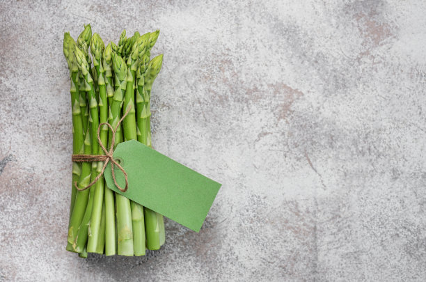混凝土背景上的新鲜绿芦笋。图片下载