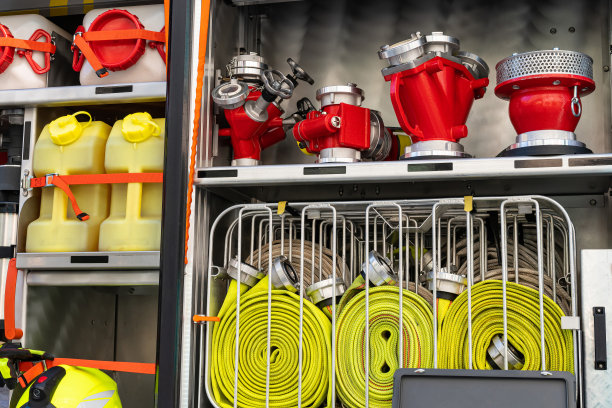 卷起的黄色消防水管和消防轨道上的各种水龙头。图片下载