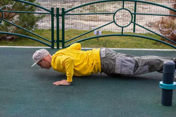 健康的年轻人在室外运动场的人造地面上做俯卧撑。较低的位置图片下载
