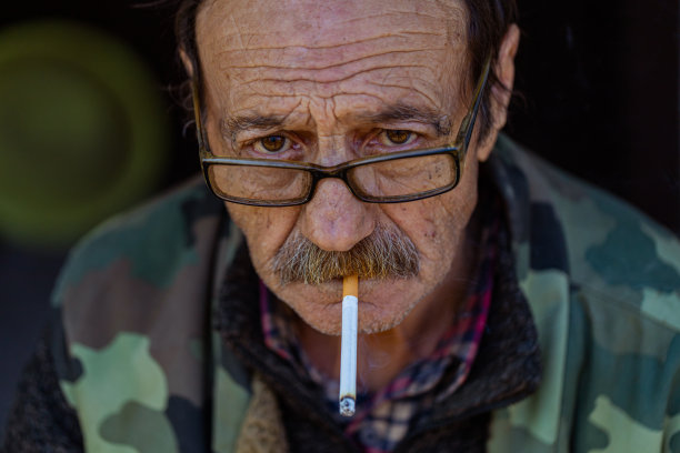 老怀旧的男人戴着眼镜，嘴里叼着烟图片下载