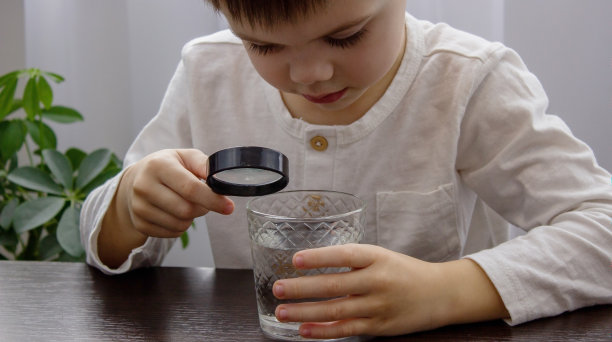孩子用放大镜看水。有选择性的重点。图片下载