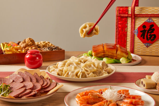 中式的节日气氛，木制餐桌，各种小吃，糕点，灯笼，礼物，红包，鱼，中餐，饺子(翻译:文字意味着吉祥和好运)图片下载