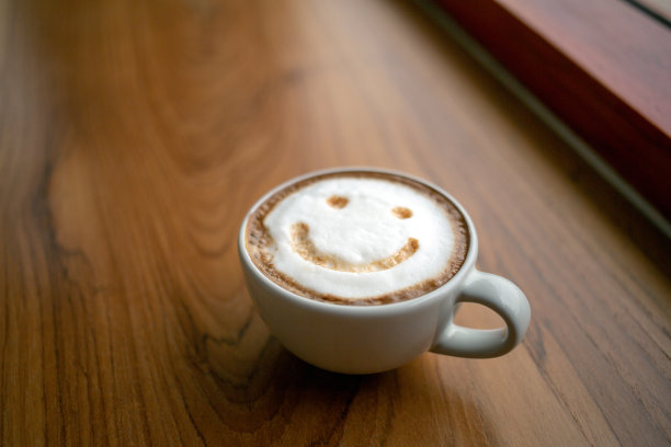 一杯卡布奇诺咖啡美味的热咖啡与泡沫牛奶和微笑的彩色背景，俯视图。早上快乐，心情好，灵感迸发图片下载