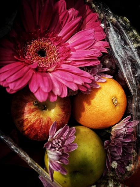 在花束中被鲜花和水果包围的橙子的选择性焦点。图片下载