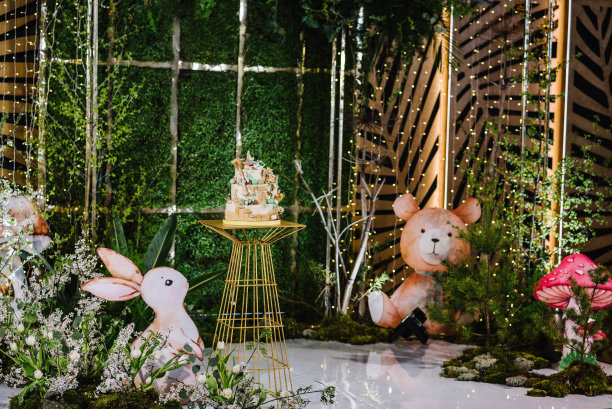 美味的接待。绿色背景上的森林风格生日蛋糕。拱门上装饰着绿叶、蘑菇、木头、树叶、兔子、熊。乡村风格，乡村装饰。儿童照片墙。孩子的聚会。图片下载