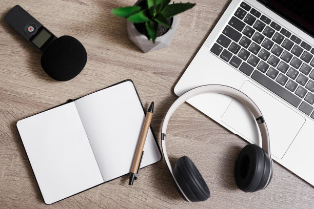 新闻和博客的概念-工作场所与笔记本电脑，麦克风，耳机，记事本和笔的顶视图图片下载