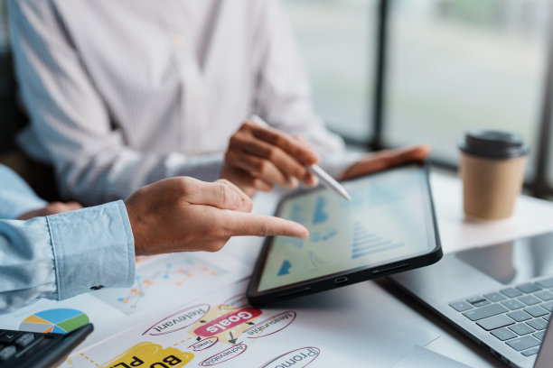 商人们在办公室里开会，一起制定商业战略，用平板电脑指着图表工作。图片下载