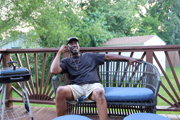 一幅黑人男子坐在庭院椅子上的肖像图片下载