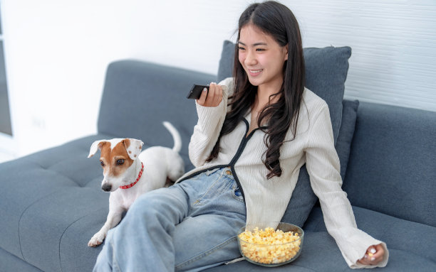 亚洲女性喜欢在家里的客厅里看电影。图片下载