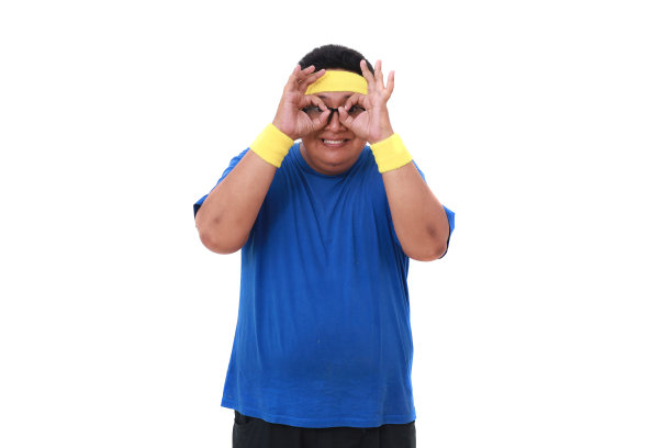 滑稽的亚洲超重男子穿着运动服站着做着双筒望远镜的手势。孤立的图片下载