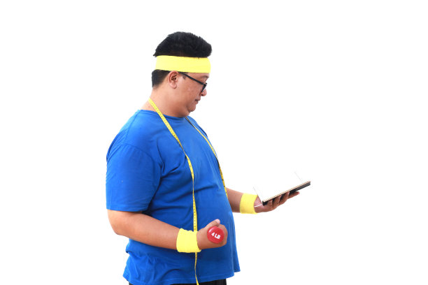 穿着运动服的亚洲超重男子站着，手里拿着哑铃和书。孤立于白色图片下载