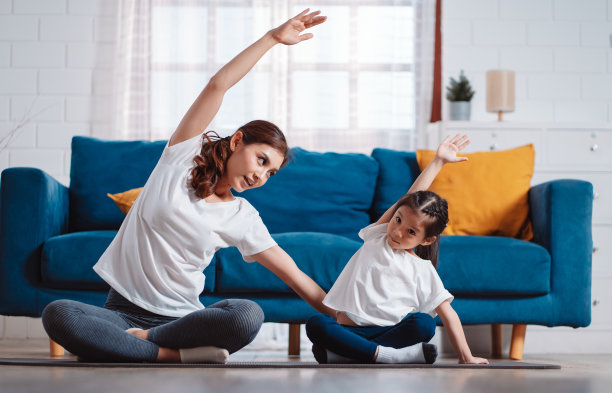 母女俩在家里愉快地一起运动。为柔韧性增强肌肉力量，运动锻炼全家一起训练的理念。图片下载