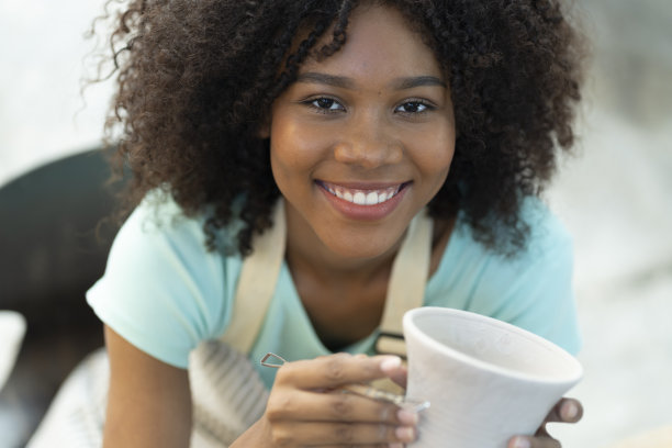 运动中的艺术:从事陶瓷雕刻艺术过程的女孩图片下载