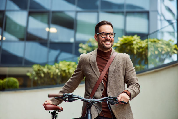 一个成功的商人推着自行车下班回家。图片下载