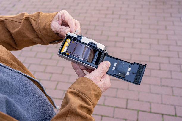 一个老人把胶卷放进他的旧相机的特写。图片下载