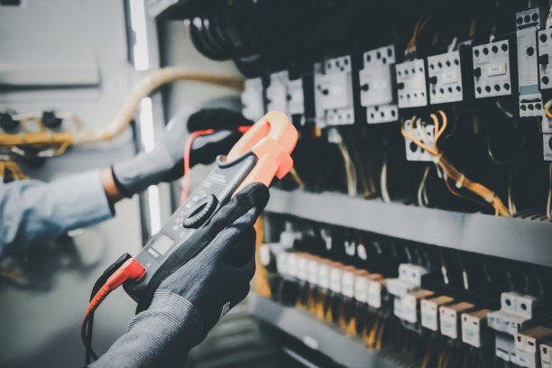 电气工程师用万用表测试电气安装和保护继电器接线。图片下载