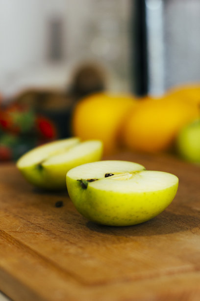 切菜板上绿苹果的两半特写。健康减肥食品的制备。有机食品。股票的照片。图片下载