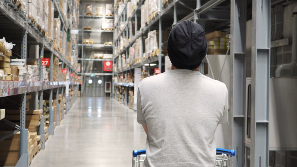 仓库存放大型货物或配送货物，并配有购物车。图片下载