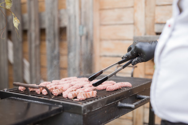 烧烤厨师在烤架上用镊子，特写图片下载