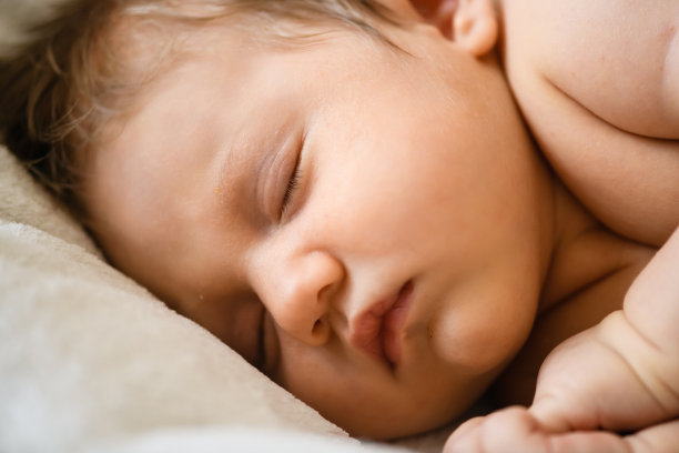 婴儿床上熟睡的新生儿特写图片下载
