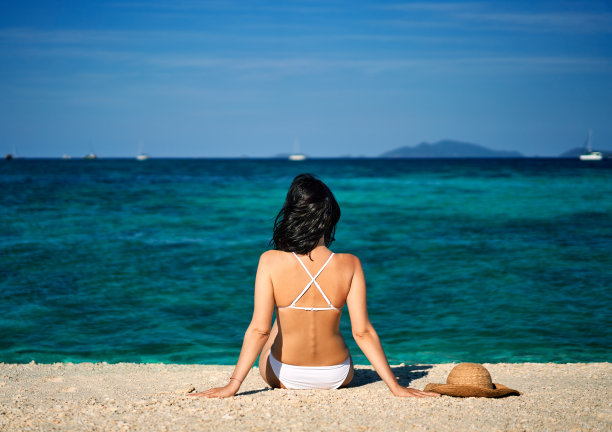 美丽的女人在热带海滩上放松图片下载