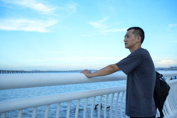 一位男乘客在观景台上看海图片下载