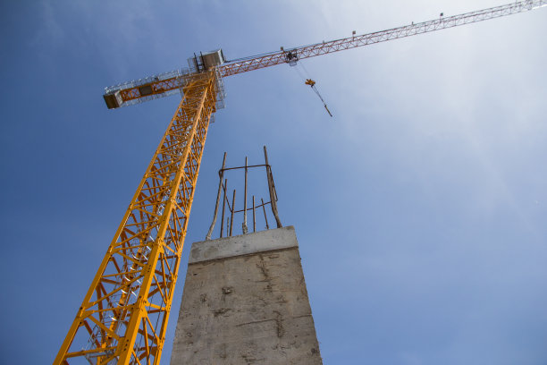 塔吊及建筑物混凝土基础。以天空为背景的施工起重机。图片下载