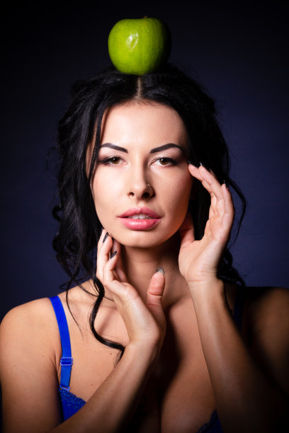 万圣节。一个可怕的邪恶女巫手里拿着一个有毒的苹果，站在蜘蛛网之间的她的巢穴里。邪恶的黑魔法。图片下载