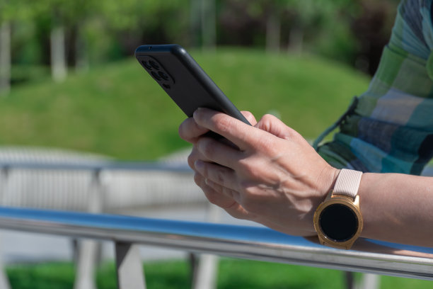 一名妇女翻看手机显示屏。年轻人用智能手机聊天。图片下载