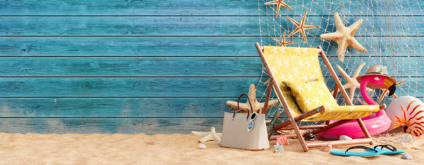 黄色沙滩椅，粉红色火烈鸟充气和蓝色木墙背景的夏季配件图片下载