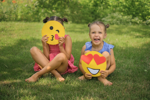 心形的笑脸和表情符号在孩子们的手中传递一个飞吻图片下载