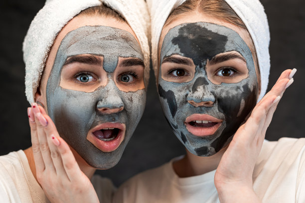 闺蜜们在白色毛巾上涂抹黑泥泥面膜隔离上黑色图片下载
