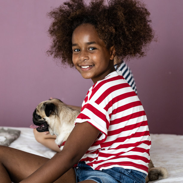 美国黑人女孩抱着狗在房间的肖像图片下载
