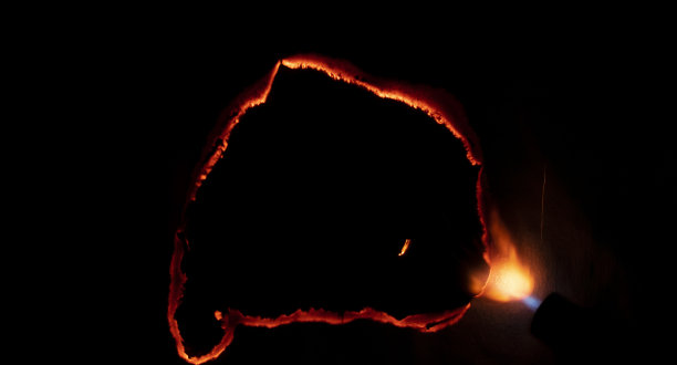 燃烧的纸，在黑色背景上发光的纸边图片下载