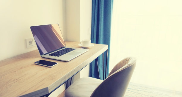 黑屏笔记本电脑和智能手机放在木桌、咖啡杯和椅子上，工作场所在室内图片下载