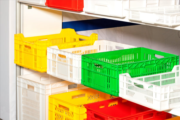 仓库货架上的彩色塑料盒子。图片下载