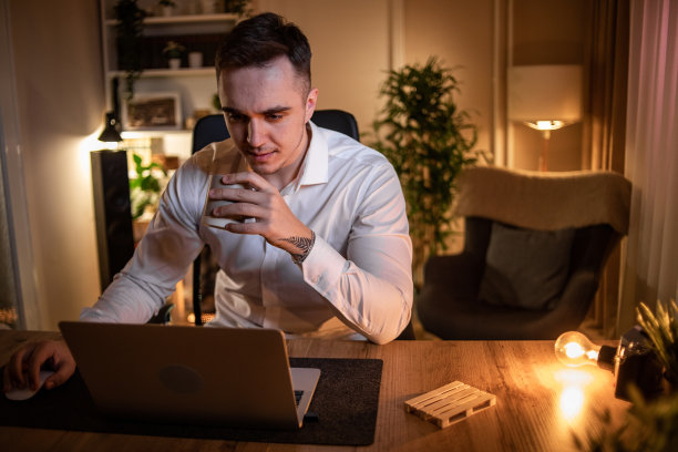 一个晚上在家工作的年轻人，在周围平静安静的时候工作图片下载