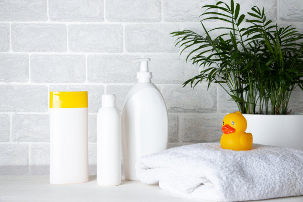 婴儿沐浴用品，毛巾，黄色橡皮鸭和洗发水瓶。儿童保育的概念。图片下载