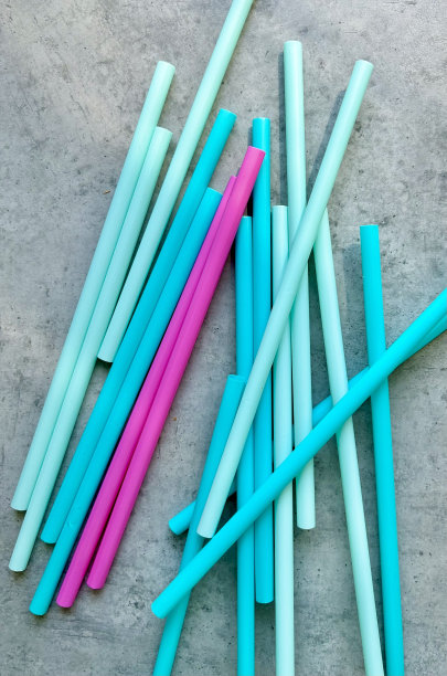 灰色背景上的彩色塑料吸管图片下载