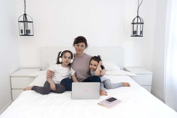 年轻的母亲带着两个女儿在网上和老师聊天。在线课程。图片下载