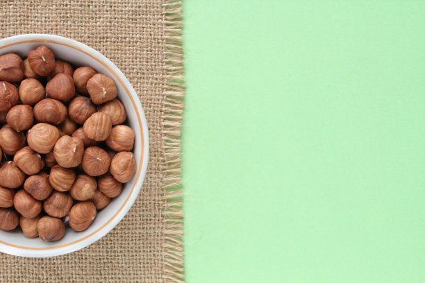帆布上的榛子和绿色背景。健康饮食，营养，素食理念。蛋白质干货有机零食。生食图片下载