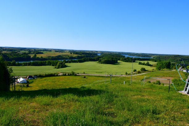 在波兰的一个阳光明媚的夏日，从一个覆盖着树木、森林、沼泽、田野和其他植物的高山俯瞰远处广阔而清澈的湖泊或河流图片下载
