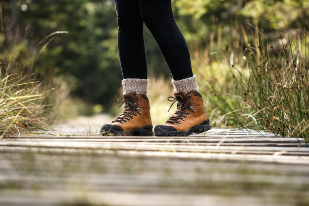 在树林里的徒步小径上的登山靴图片下载